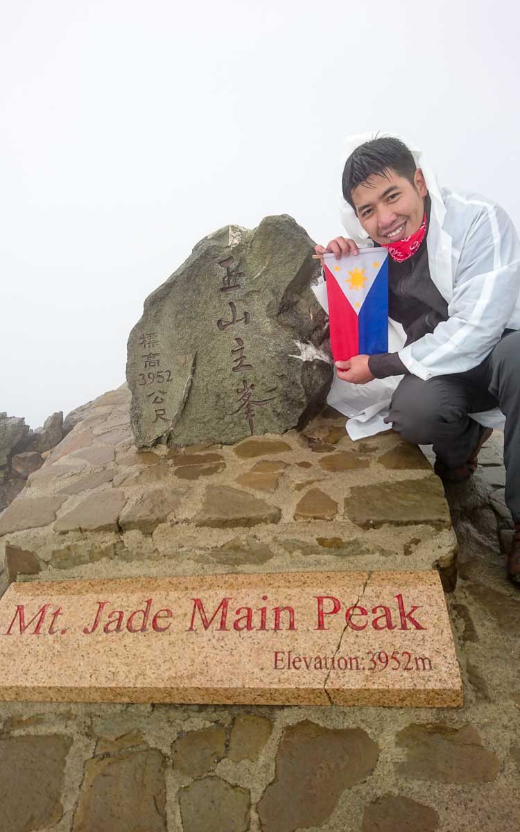 Mount Yushan summit marker at 3,952 meters with successful hiker