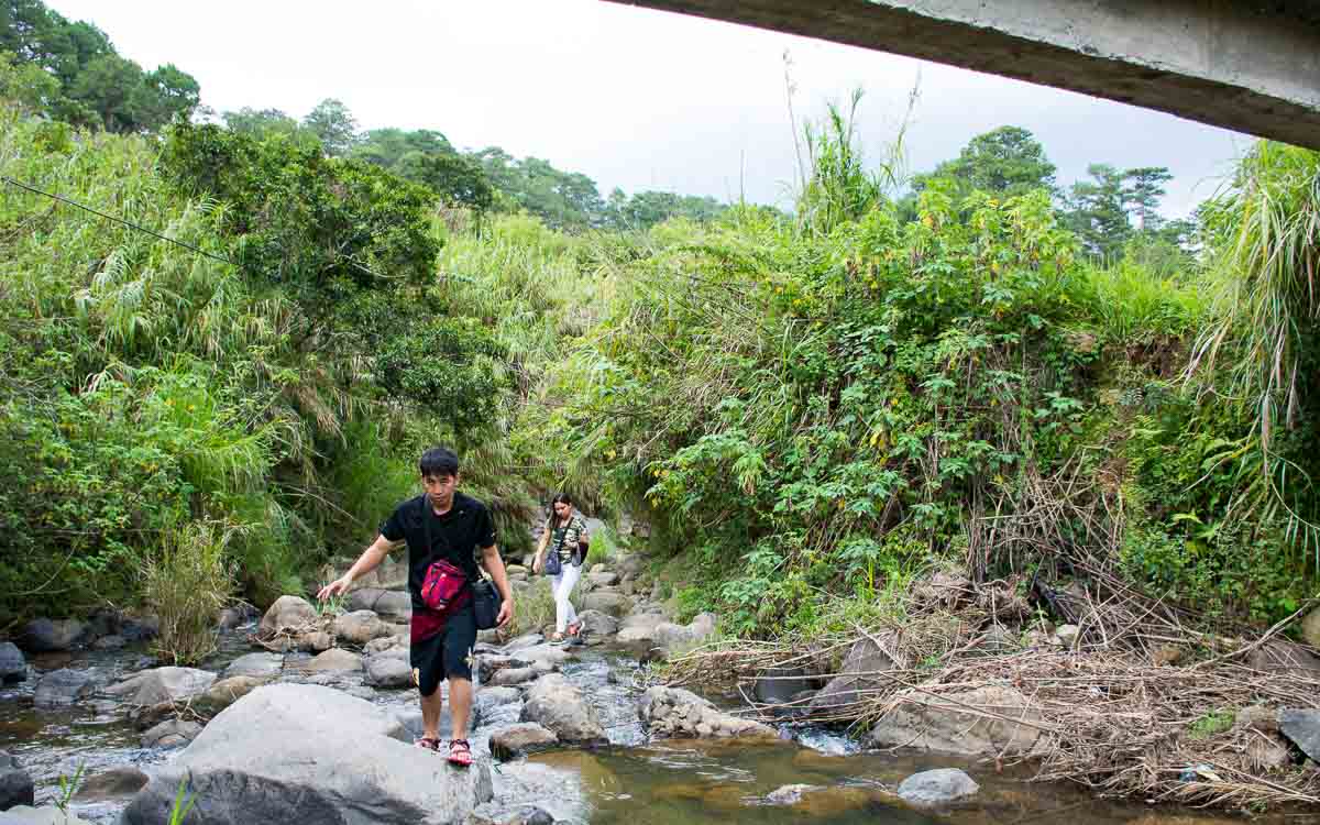 Adventure hikers carefully navigating rocky stream crossings on the trail from Echo Valley to Bokong Falls
