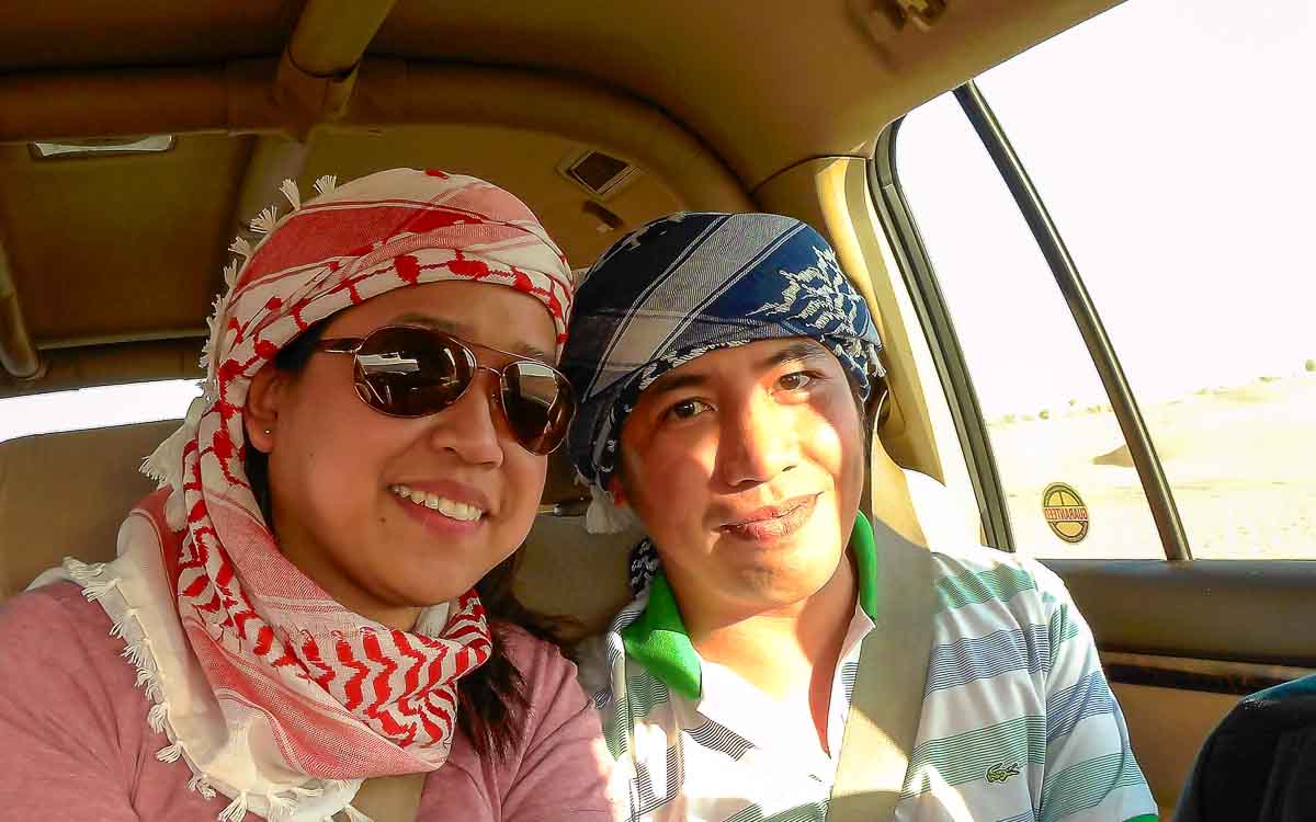 Couple enjoying exciting dune bashing adventure inside 4x4 vehicle Dubai desert
