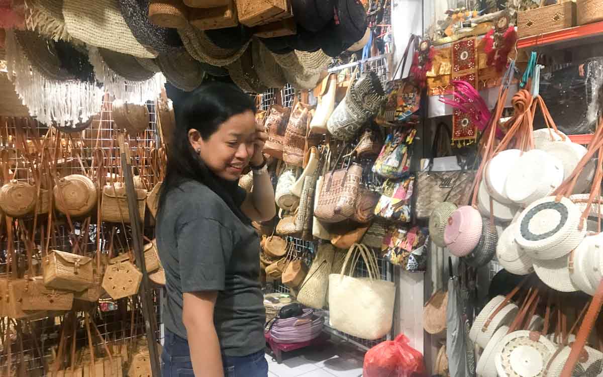 Colorful display of traditional rattan bags and Balinese souvenirs at Ubud Traditional Market with various sizes and designs
