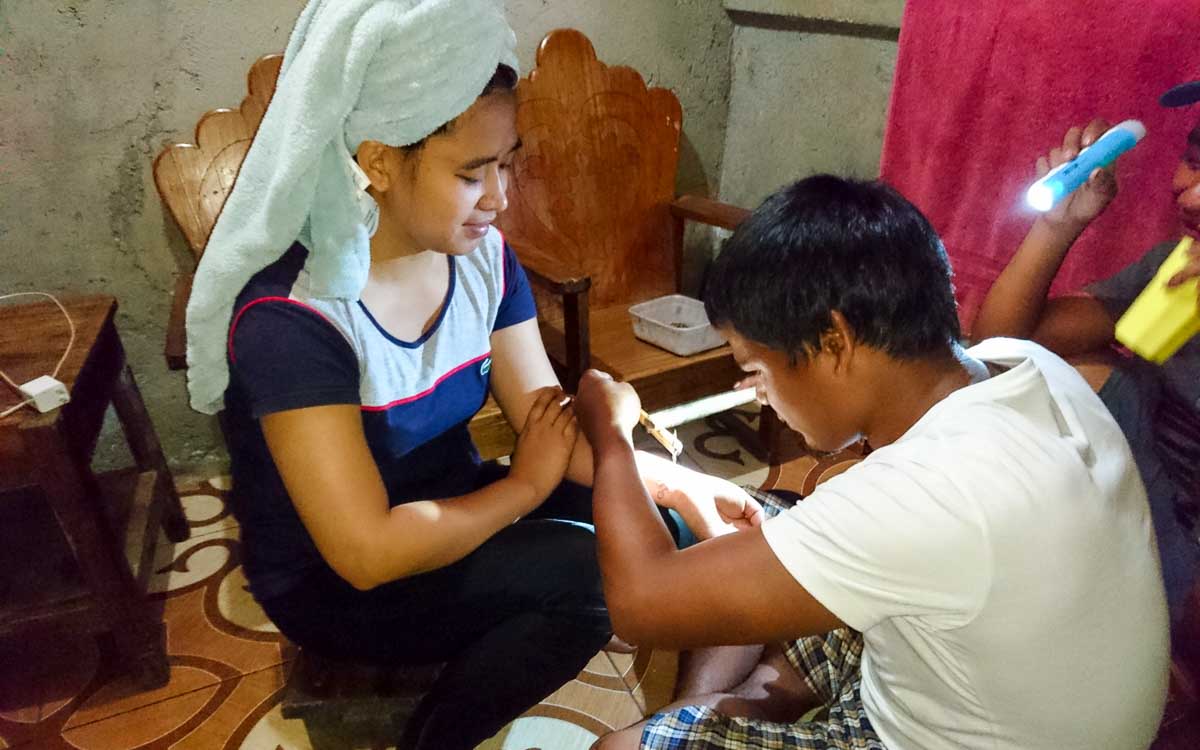 Alex receiving a tattoo at Buscalan