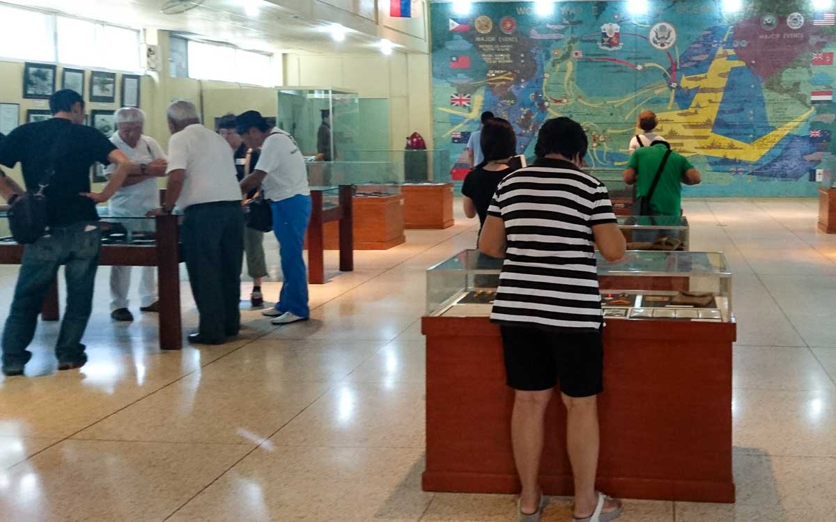 a group of people checking the collection of artifacts inside the Pacific War Museum at Corregidor