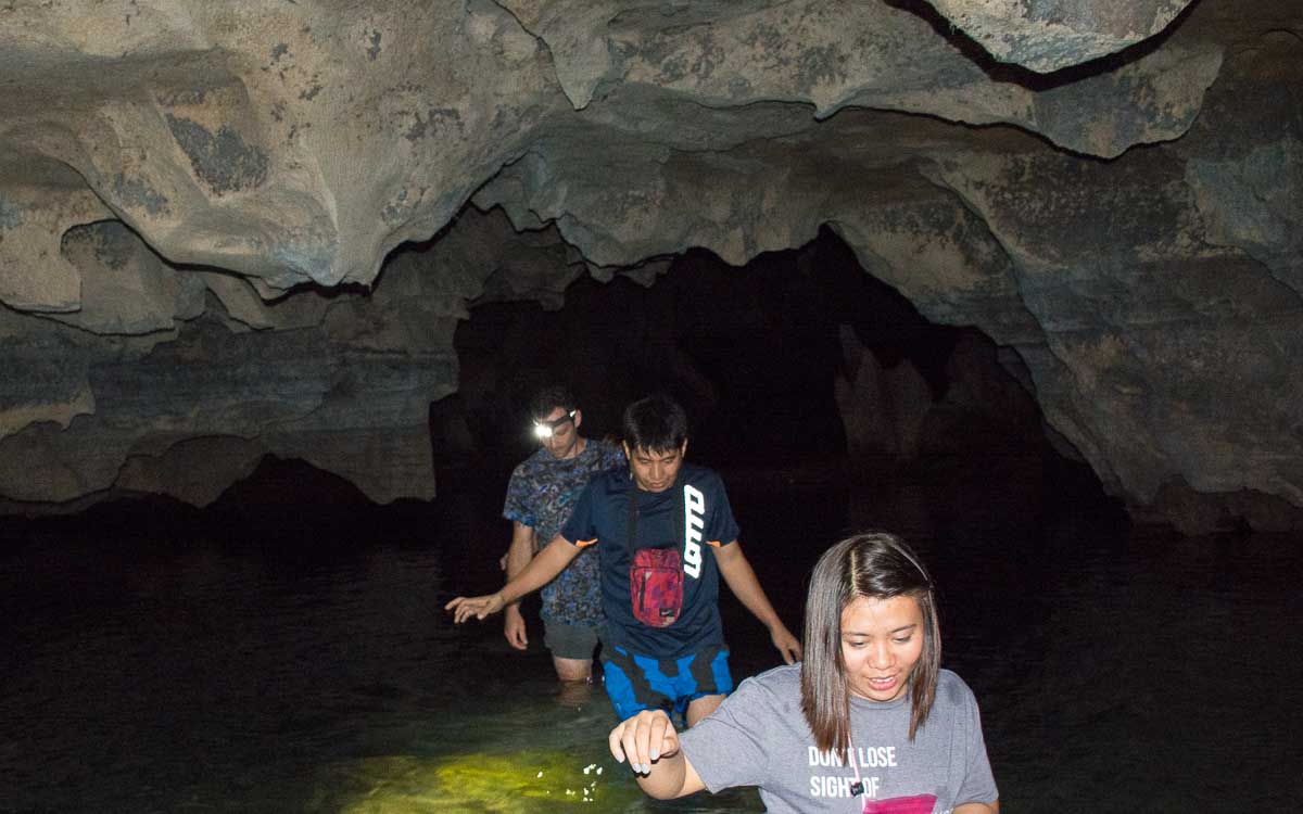 Jasper, Nathaniel, and Hanah wading to the water in Lumaing Cave