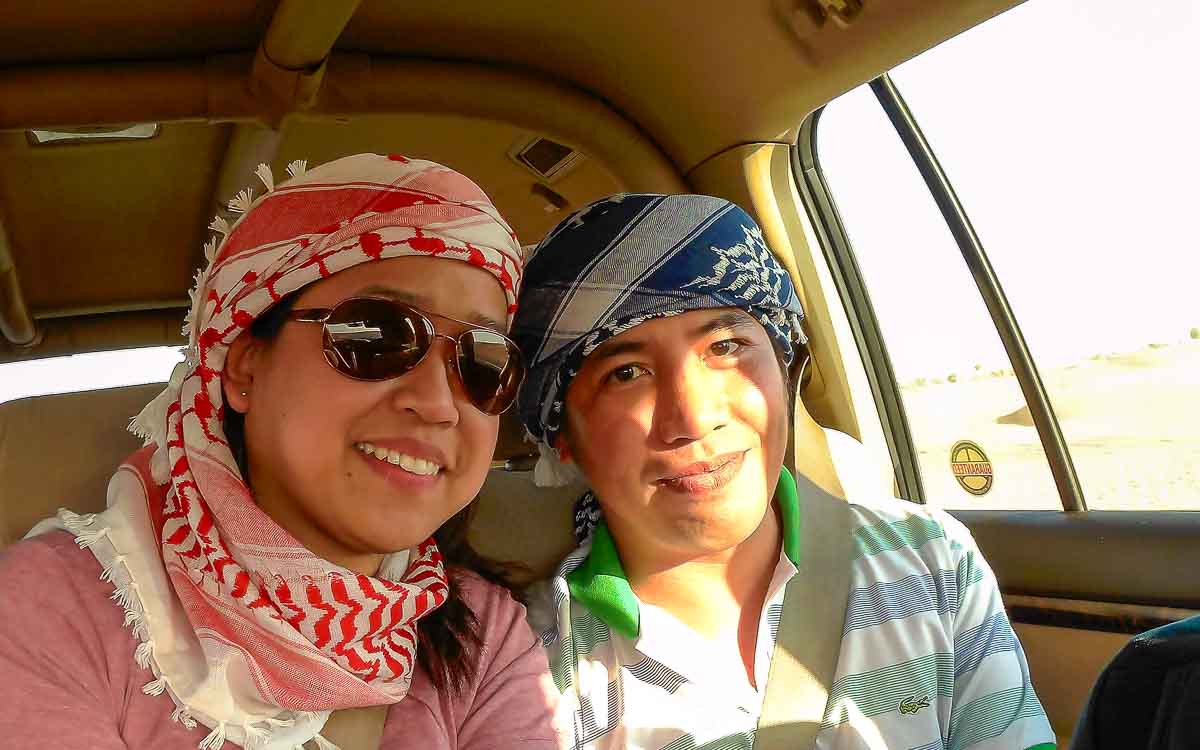 A couple enjoying dune bashing inside a 4x4 vehicle during desert safari in Dubai