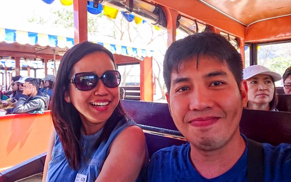 a man and woman taking a selfie inside the tram vehicle at Corregidor day tour