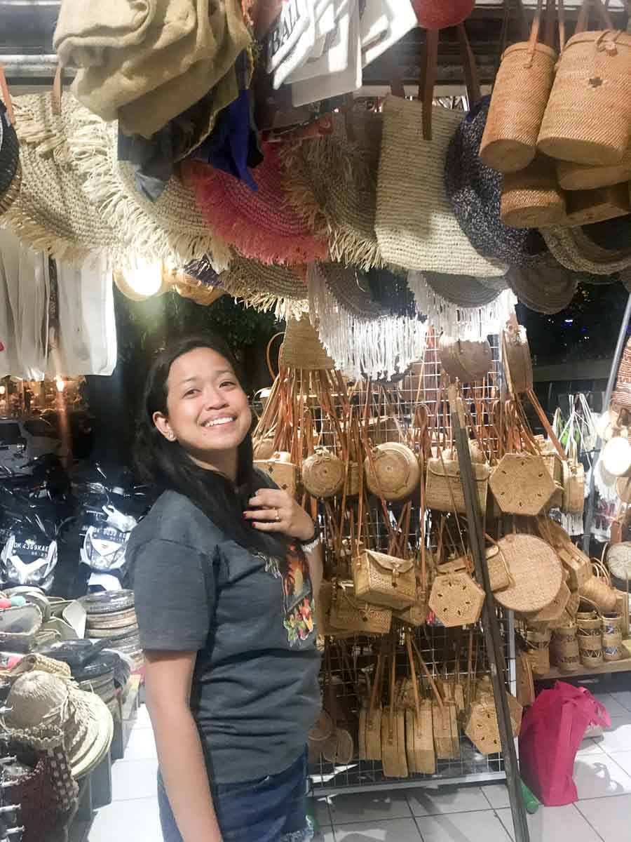 A tourist woman inspecting bags at Ubud Market