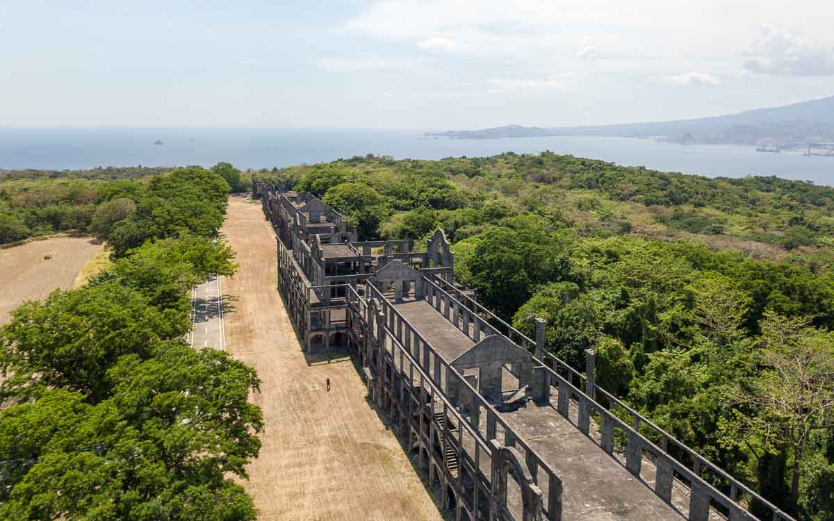 Aerial view of the ruins of Mile Long Barracks at Corregidor surrounded by green trees