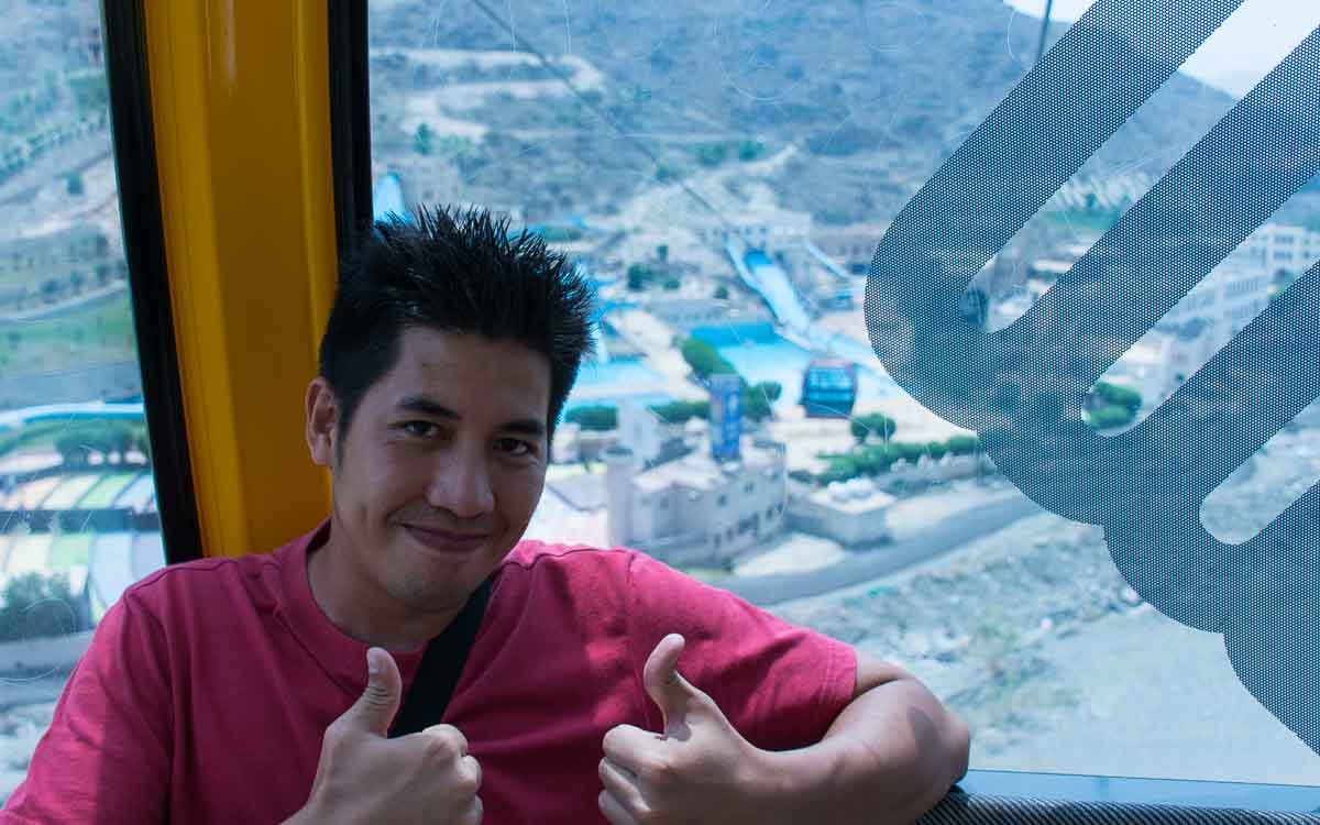 A man wearing a red shirt inside the cable car