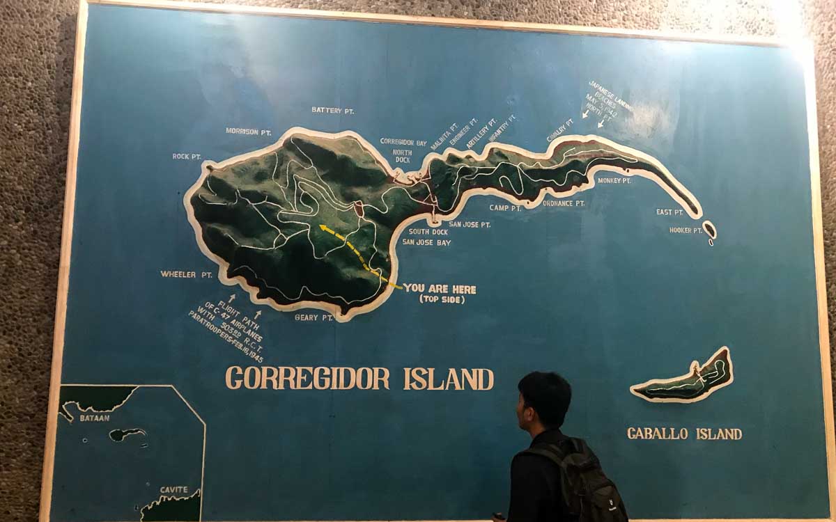 a man staring at the map of corregidor island inside the Pacific War Museum