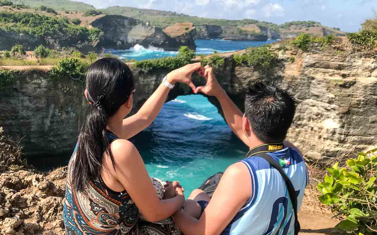 Couple making heart-shaped hands at Broken Beach