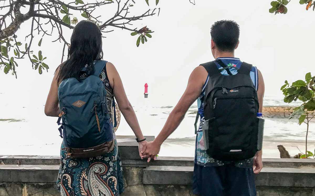 Couple holding hands while gazing at the sea at Sanur Port