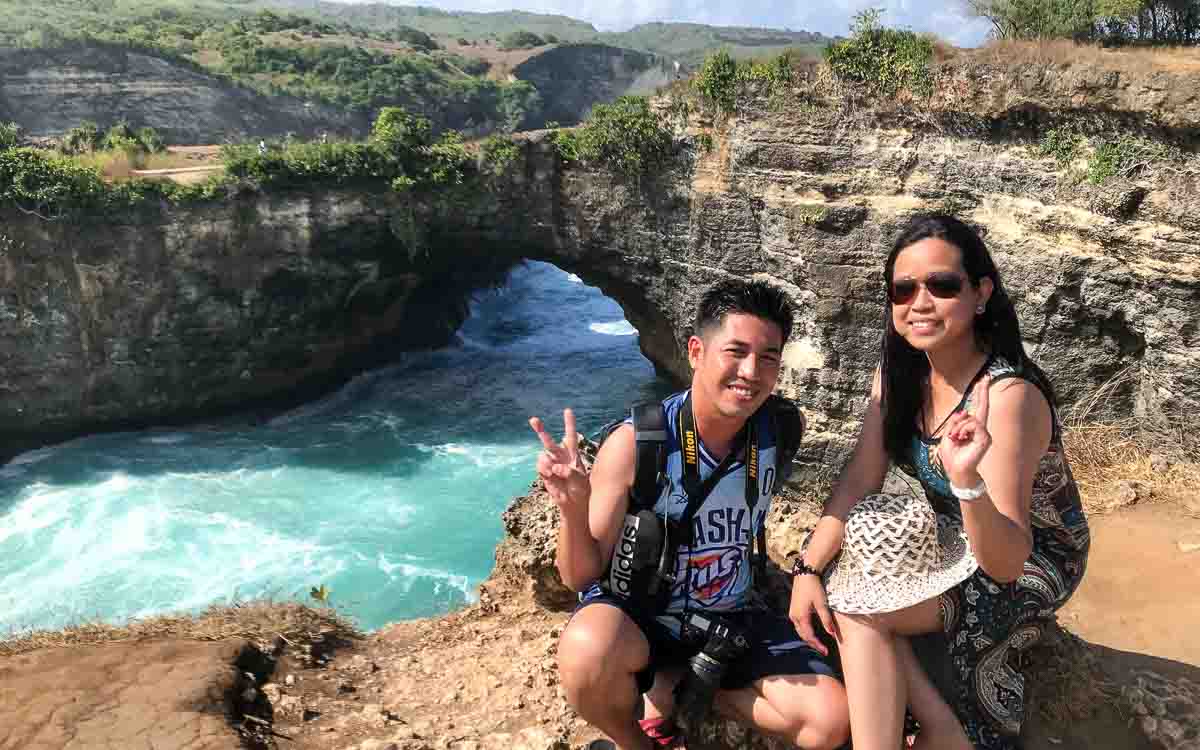 Couple sitting near the edge of the cliff at Broken Beach