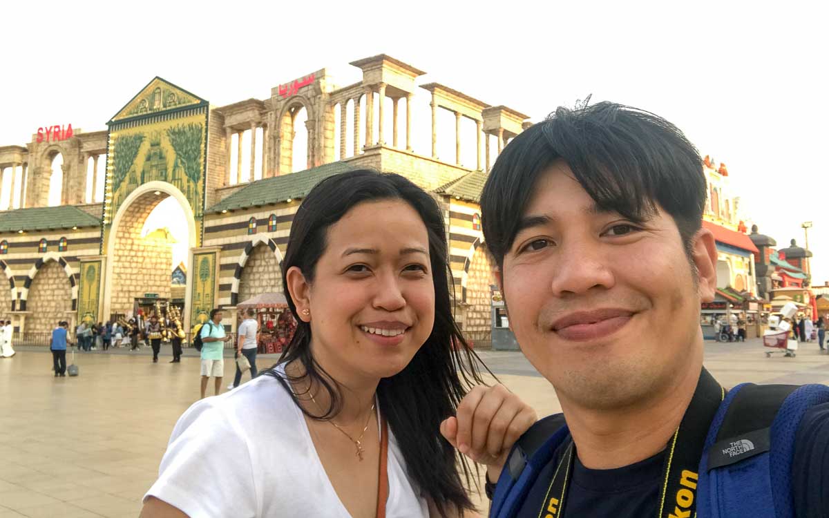 A couple poses in front of the Syria pavilion.