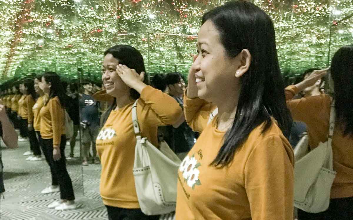 Visitor experiencing the Infinity Room at Museum of Illusions Dubai with endless mirror reflections