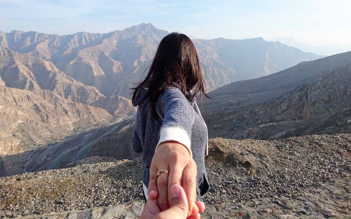 A hand holding a woman's hand at Jebel Jais.