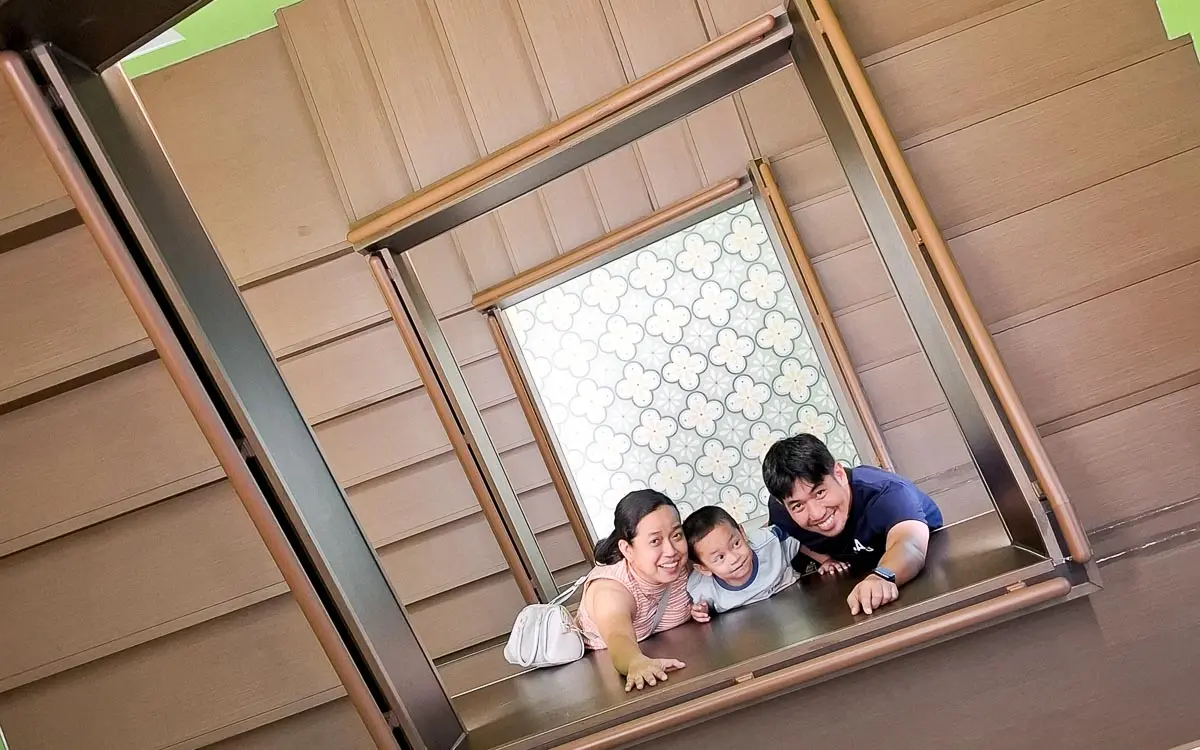 Family posing at the upside-down staircase installation inside Space & Time Cube SM North EDSA