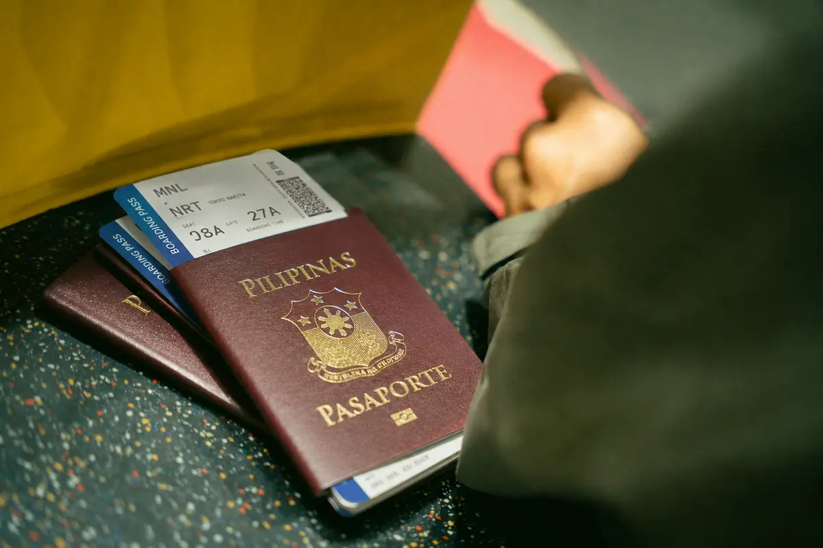 Philippine passport with travel documents including visa, boarding pass, and ID